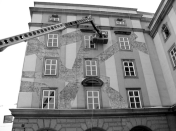 Épület homlokzatának felújítása látható, emelőkosaras szerkezettel és ablakokkal.